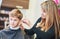 Barber or hair stylist at work. female hairdresser cutting child hair