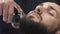 Barber hand cutting beard with clipper at barbershop. Closeup video, 4k. Barber works with the electric trimmer