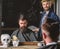 Barber and hipster client with beard checking haircut in mirror, dark background. Hipster and barber talking during