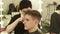 Barber making male haircut with electric shaver in barber shop. Close up hairdresser cutting hair with hair machine in