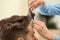 Barber making stylish haircut with professional scissors in beauty salon,