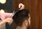 Barber making stylish haircut with professional scissors in beauty salon