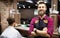 Barber man in an apron with arms crossed and happy in salon