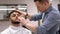 Barber master arranges a client`s beard, massages the skin of the face