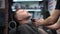 Barber master shaving handsome mature bearded man using electric shaver in salon