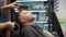 Barber master shaving handsome mature bearded man using electric shaver in salon. Hair artist making beard style for person