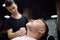 Barber master shaving handsome mature bearded man using straight razor in salon. Hair artist making beard style for person in male