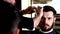 Barber performs a haircut with scissors and combs