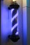 Barber pole turning swirl LED light sign in dark background