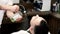 Barber pouring green liquid on client\'s face in salon