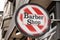 Barber round shop sign in vintage hairdresser wall white red colors