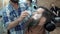 Barber shaves men with a long beard with straight razor blade in s hair salon or barbershop. Man`s haircut and shaving