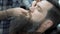 Barber shaves men with a long beard with straight razor blade in s hair salon or barbershop. Man`s haircut and shaving