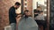Barber shaving bearded man with electric razor in barber salon. Bearded man getting trimming beard with shaver in male
