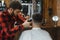 Barber shop. Man with wife in barber's chair, hairdresser Barbershop styling his hair