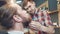 Barber spreading oil on man\'s beard