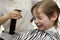 Barber sprinkles water on child hair