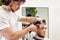 Barber trim hair with clipper on handsome bearded man