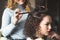 A Barber twists the hair of a young girl. Beautiful curly locks. Smiling Barber