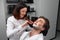 The barber woman shaves beard with razor