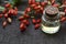 Barberry essential oil in a glass bottle on old wooden table for aromatherapy,skin care or spa.Berberis vulgaris herb extract.