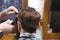 Barbers hands making haircut to man using trimmer