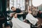 Barbers make a stylish hairstyles to men in a barbershop