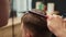 Barbershop, close-up: woman barber cuts men\'s hair with scissors