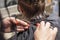 barbershop cuts the ends of wet clean hair on the back of the client\'s head scissors