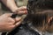 barbershop cuts the tips of wet clean hair on the back of the boy\'s head scissors