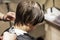 barbershop cuts the tips of wet clean hair at the back of the head