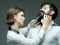 Barbershop or hairdresser concept. Woman hairdresser cuts beard with scissors. Guy with modern hairstyle visiting