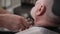 barbershop, male haircutter uses a professional trimer to trim the beard and mustache for an elderly client, close-up