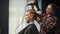 Barbershop: woman barber blow-dries a men\'s hair