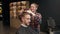 Barbershop: woman barber cuts men\'s hair with scissors