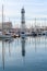 Barcelona, Spain-April 12, 2023. A tranquil scene of a sailboats gliding in the harbor with reflections on the still water,