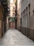 Barcelona, Spain - august 2019: empty narrow street between buildings, long view. Empty pavement between houses