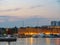 Barcelona, Spain - august 2019: a lot of yachts moored to wharf, long view. Illuminated houses on sea shore. Evening sky