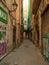 Barcelona, Spain - august 2019: narrow pavement between old buildings, long view. People at the end of street. Vintage