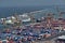 Barcelona, Spain - May, 27 2018: Blue and red metal cargo containers being loaded on cargo ship by huge port crane at the Sea Port