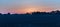 Bare agricultural field with trees at sunrise.