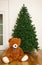 Bare artificial christmas tree with teddy bear