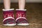 Bare child legs and feet in red winter christmas boots with ornament pattern