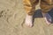 Bare children`s feet on the beach. close-up