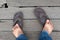 Bare feet of Asian men standing on wooden floor. Broken shoes