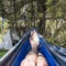 Bare feet of a climber resting in a hammock against the backdrop of mountains. natural photography in a hike from the first person