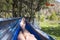 Bare feet of a climber resting in a hammock against the backdrop of mountains. natural photography in a hike from the first person