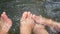 Bare feet of a couple in refreshing natural hot spring water stream