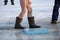 Bare feet in galoshes after swimming in the river in winter on ice at Epiphany