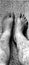 Bare feet on granite floor with her tall hairy legs.  own photo taken at home b/w
